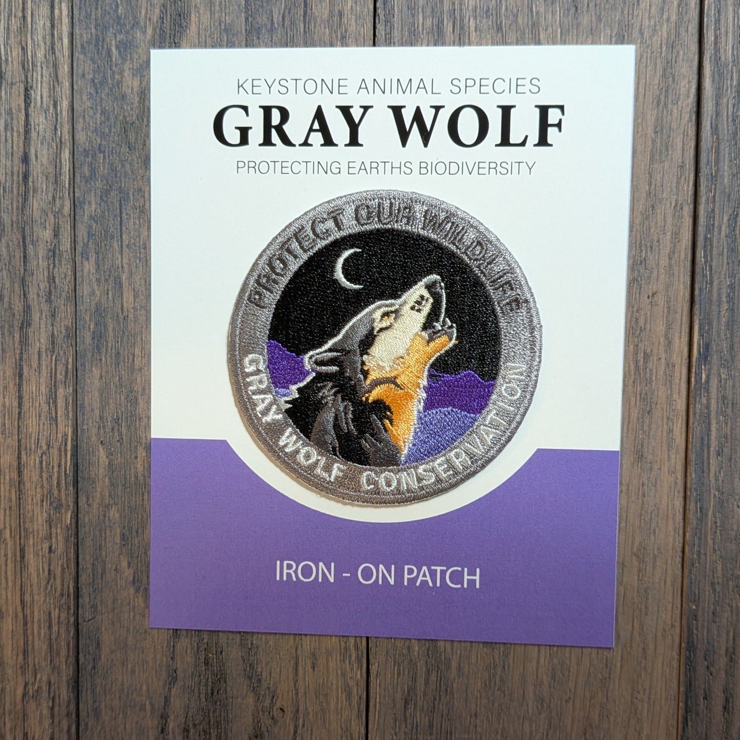 Gray Wolf Embroidered Conservation Patch has royal purple mountain and dark grey colored mountain background. Keystone animal species collectors edition.