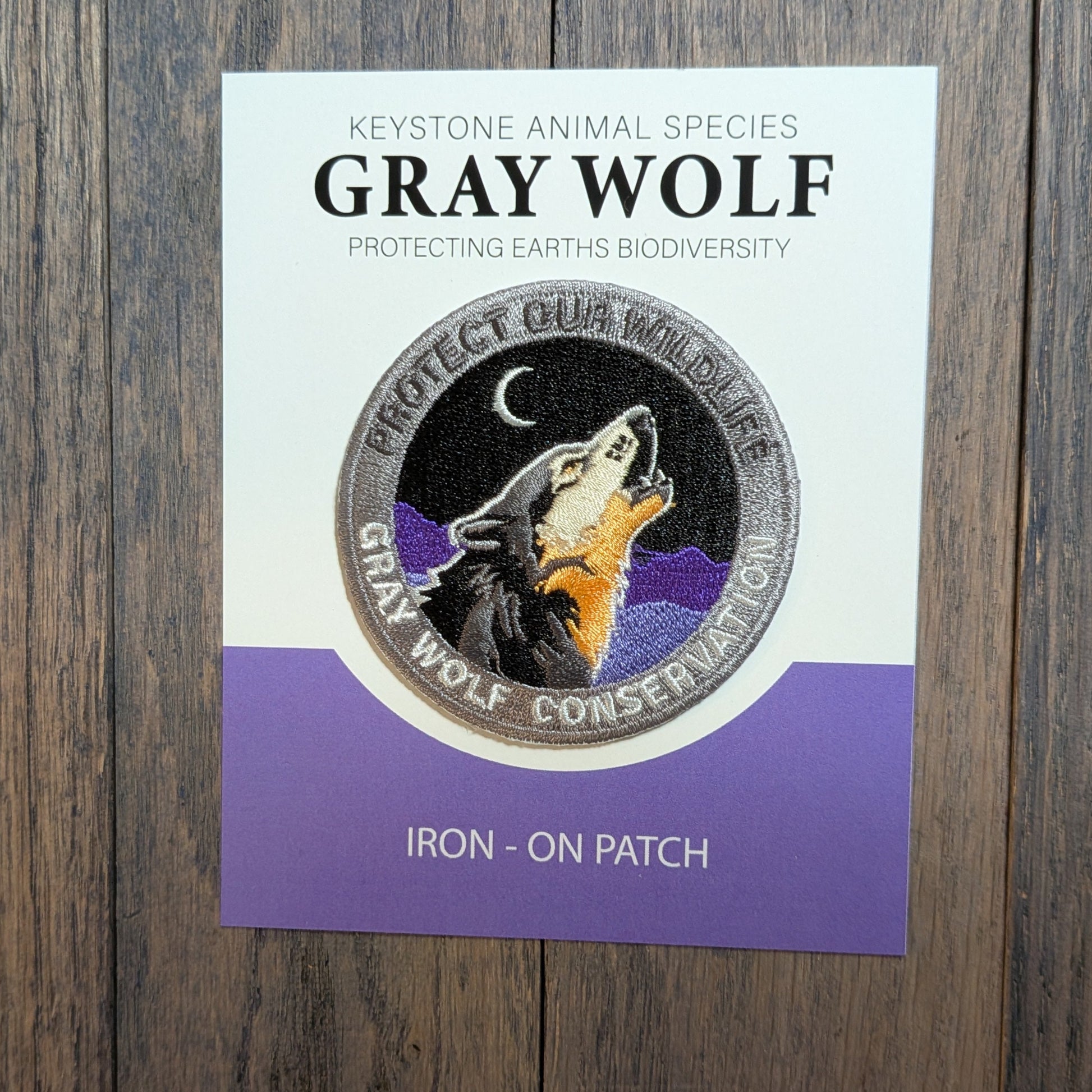Gray Wolf Embroidered Conservation Patch has royal purple mountain and dark grey colored mountain background. Keystone animal species collectors edition.